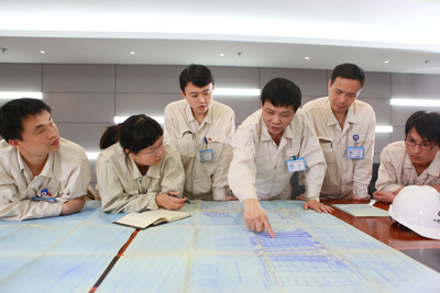 公司总经理冯伟忠与科研技术人员研究图纸探讨问题